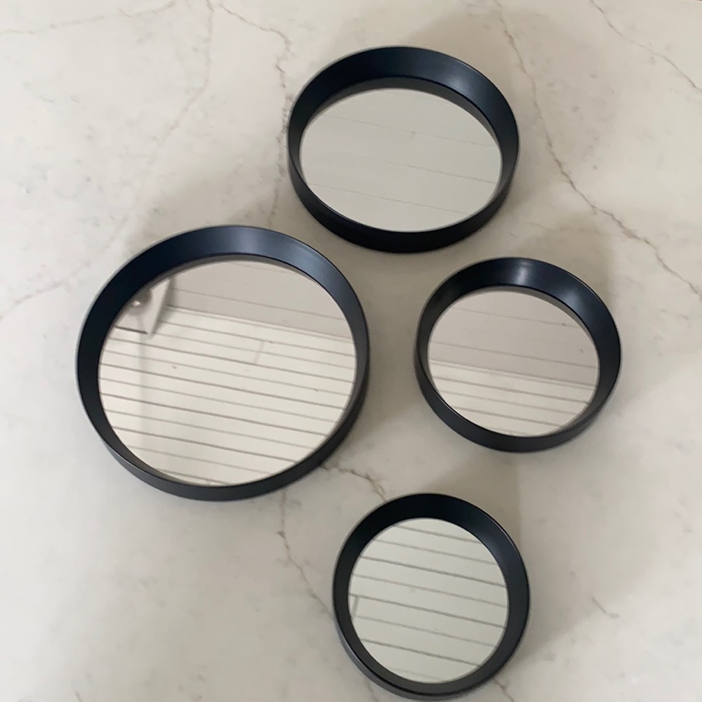 4 decorative mirrors framed in black. 6, 7, 9 and 10 inches in circumference.